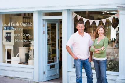 Couple standing in front of organic food store smiling