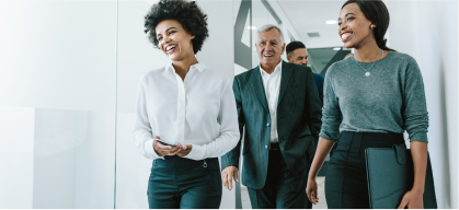 A group of people walking down a hallway together talking